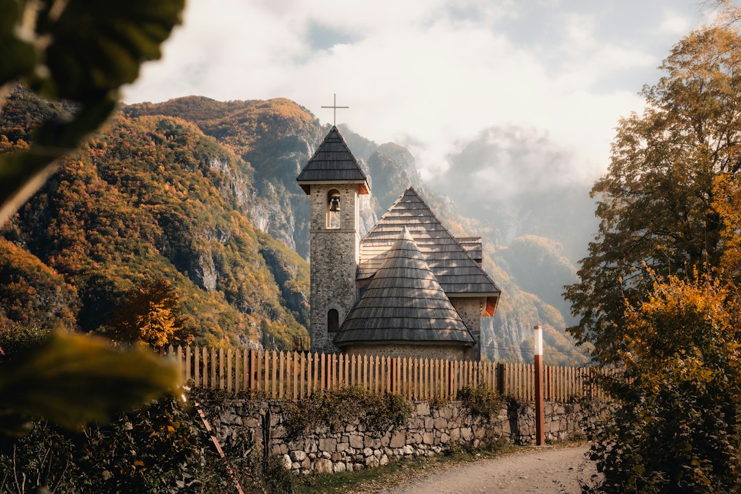 Theth village Albania stone houses mountain backdrop morning mist