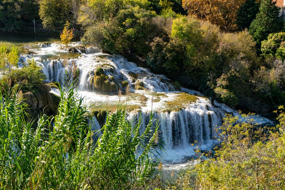 Hikers on wooden boardwalk overlooking Štrbački Buk waterfall Bosnia
