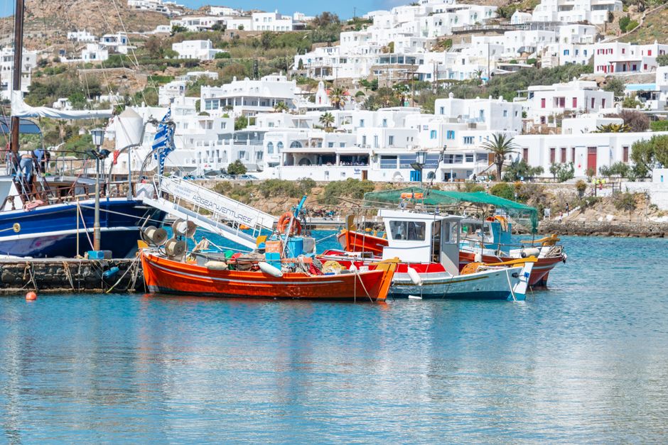 Livadi harbor Astypalaia pastel buildings fishing boats evening