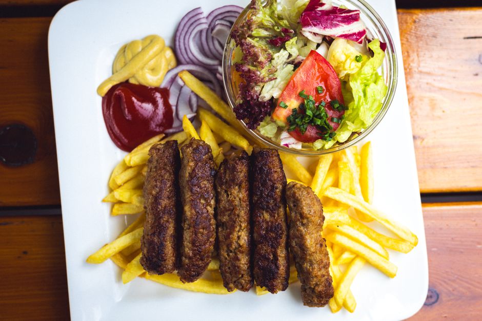 Cevapi grilled meat sausages Mostar Bosnia Herzegovina traditional food served with bread onions