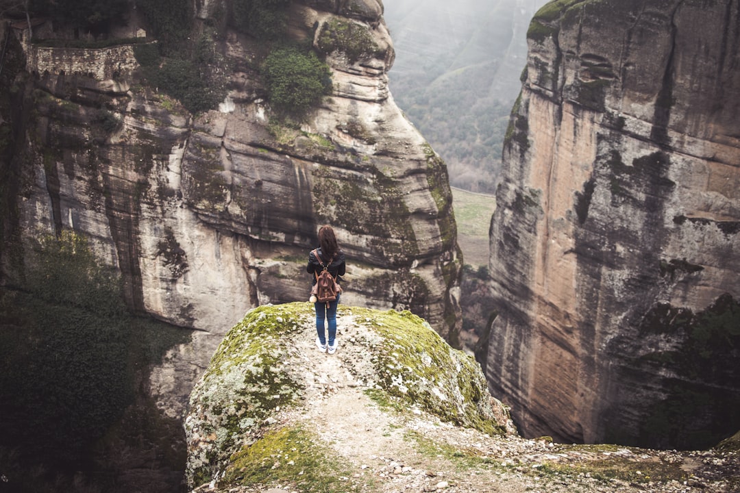 hiker climbing steep rocky path Meteora Greece trail