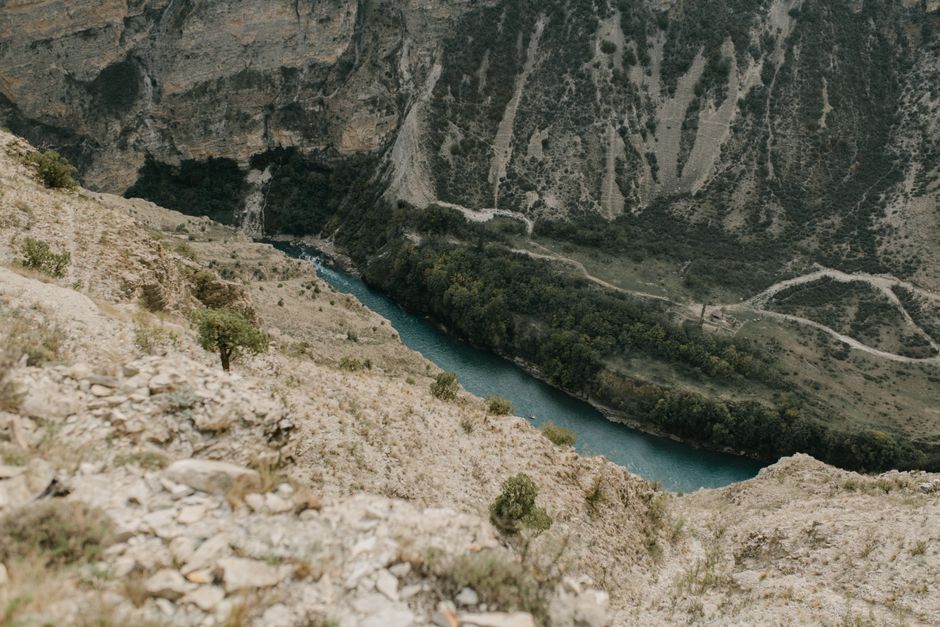 Hiker on rocky trail overlooking Tara River Canyon green valley below