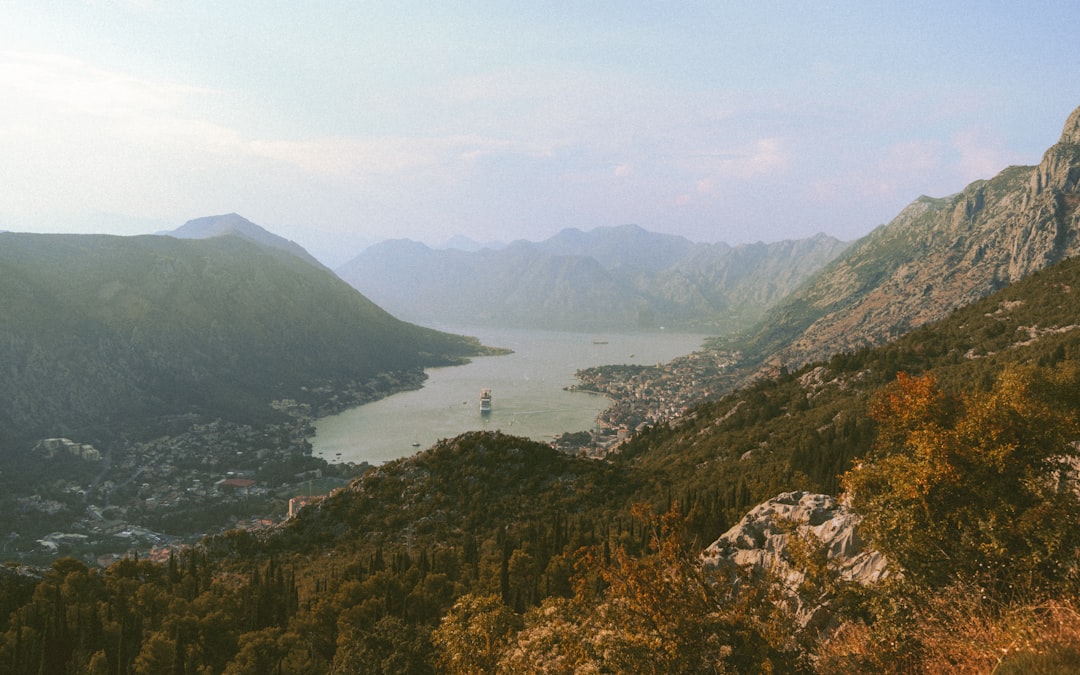 Cyclist riding narrow mountain road Montenegro Bay of Kotor view