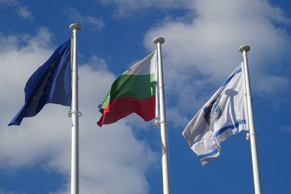 Bulgarian passport and national flag on desk