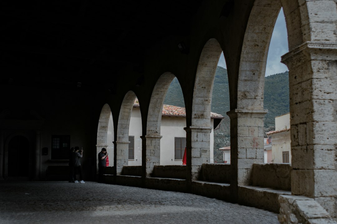 Studenica Monastery cloister stone arches monks walking