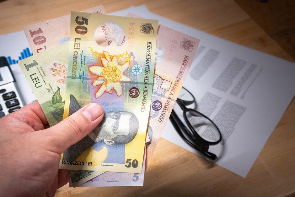 Romanian tax documents and calculator on desk