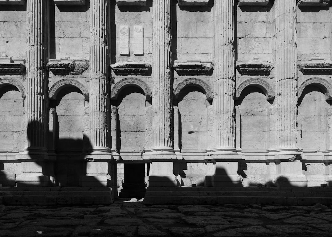Studenica Monastery stone cloisters arches columns monk walking rain shadow