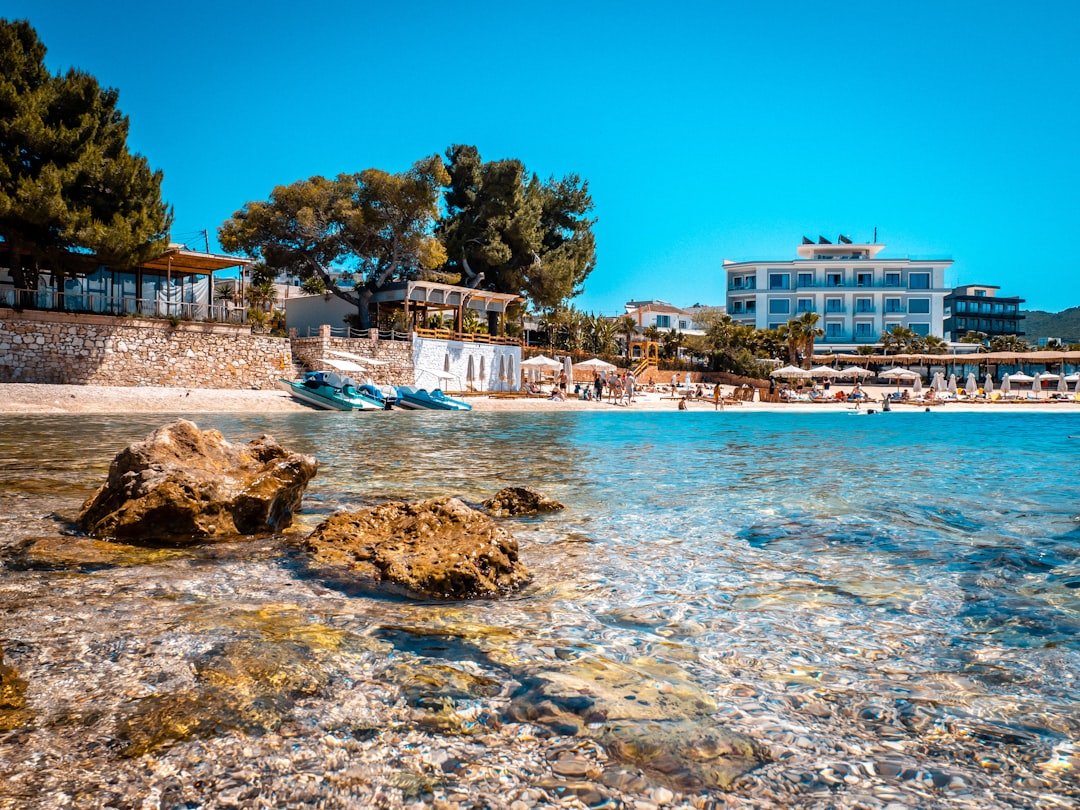 Ksamil Beach Albania white pebbles turquoise water sunbeds