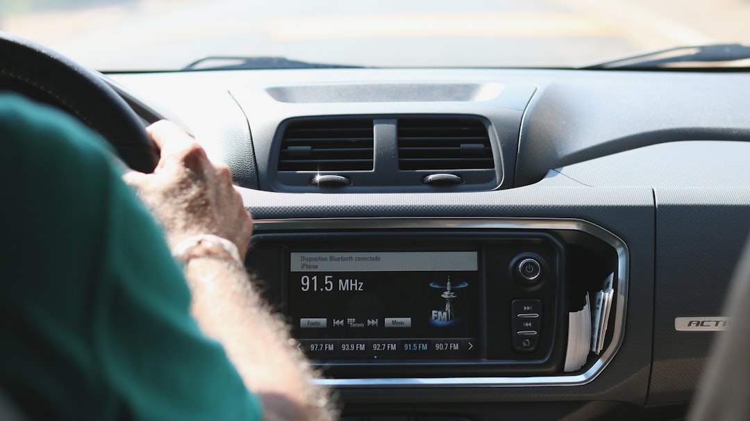 Serbian driver adjusting car climate control dashboard