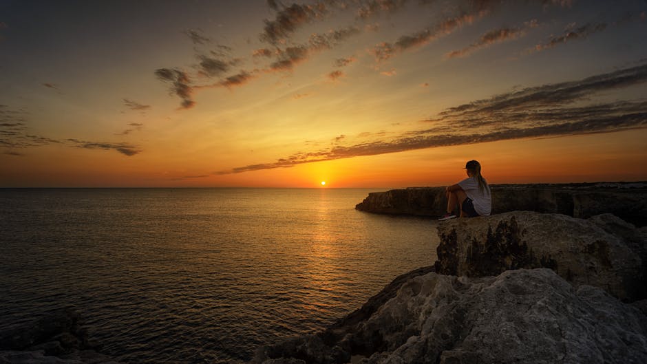 Cyclist sitting on rock overlooking sea Montenegro sunset relaxed