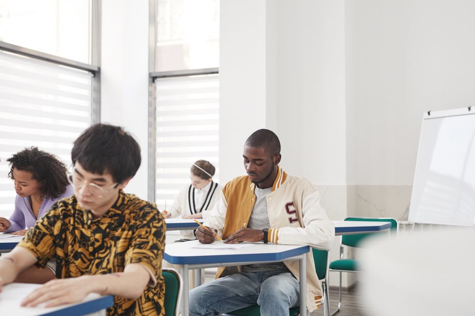 Students taking a written exam in a crowded classroom