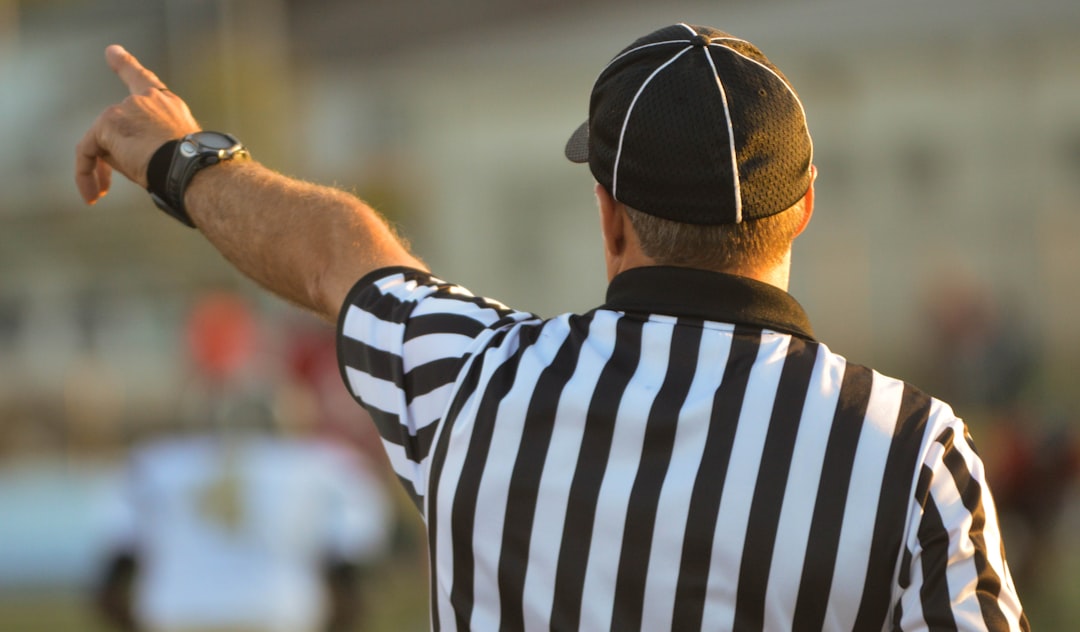 Referee signaling foul during international football match