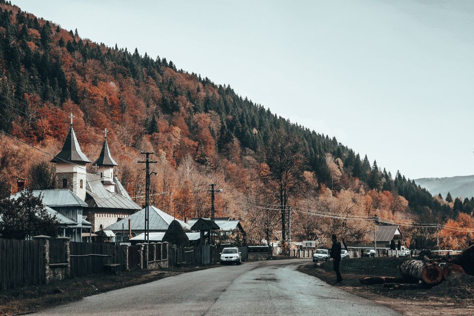 Novaci village Romania traditional houses mountain backdrop evening