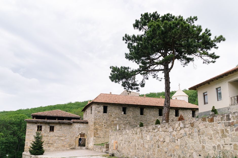 Rila Monastery courtyard stone buildings pine trees peaceful atmosphere
