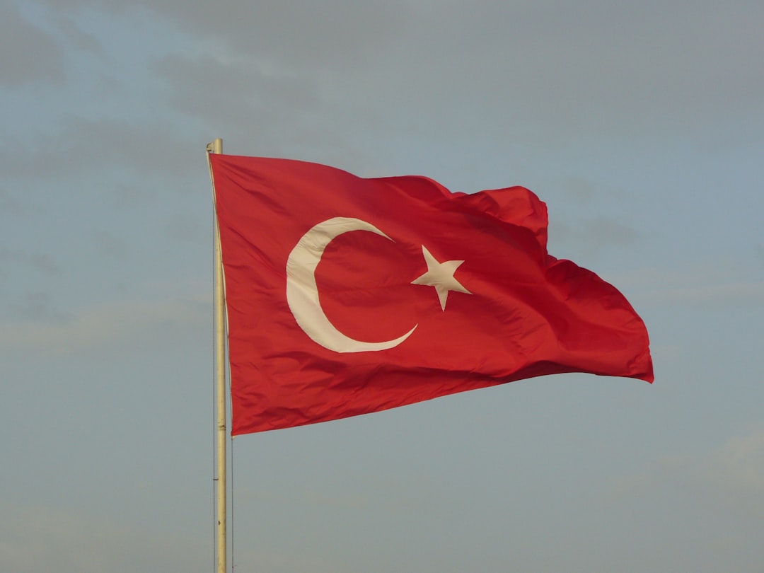 Turkish flag flying over Ankara cityscape sunset