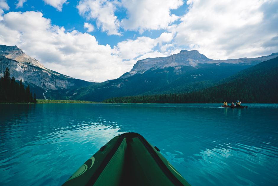 Kayaker paddling on Crno Jezero Durmitor with Bobotov Kuk peak background