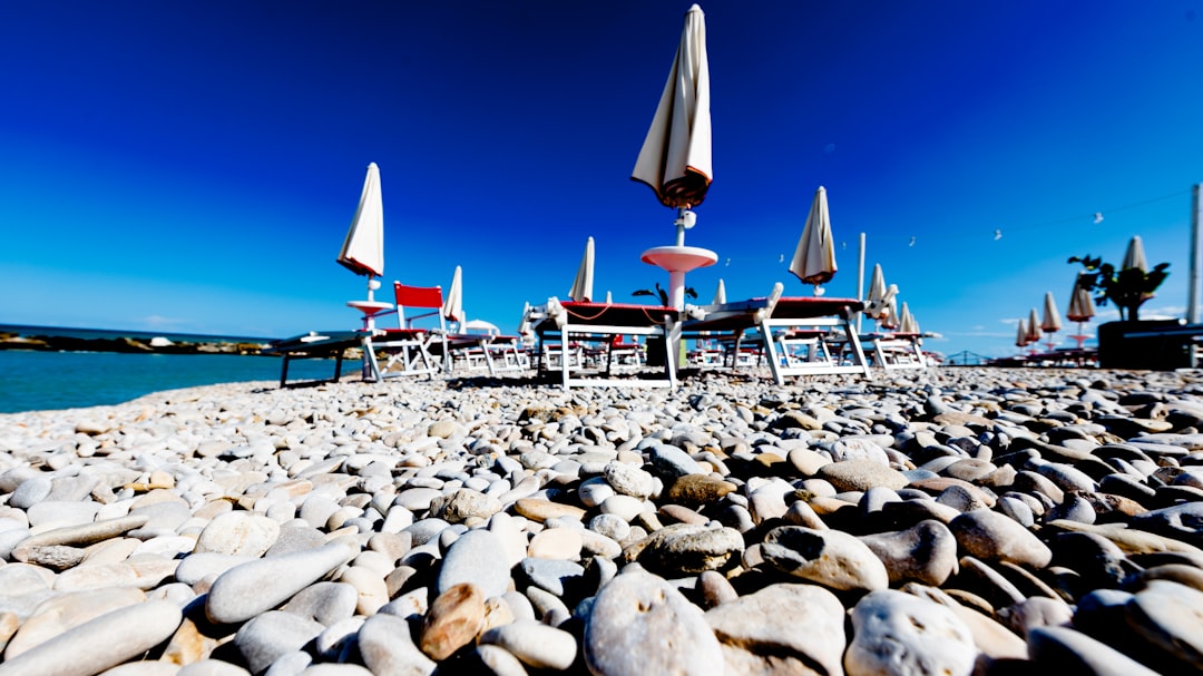 Sveti Stefan main beach pebbles blue water sunbeds
