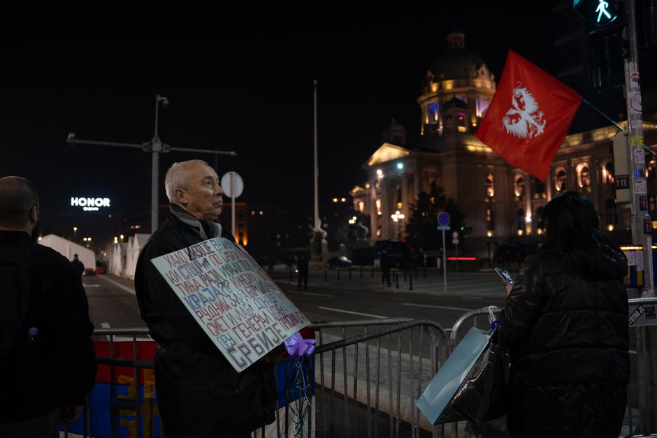 Protest crowd holding Serbian flags Belgrade street